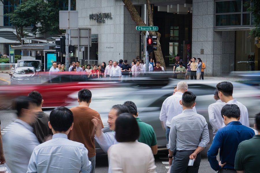 Pedestrians wait to cross a road in Singapore, 31 August 2023. (Nicky Loh/Bloomberg)