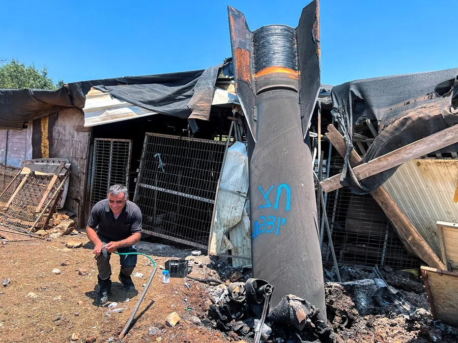 A man poses next to apparent remains of a ballistic missile following a missile attack by Iran on Israel, in northern Israel, on 24 June 2025. (Avi Ohayon/Reuters)