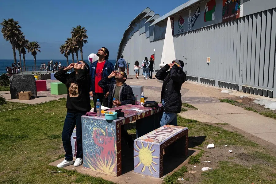 People wear special sunglasses to observe the partial solar eclipse in Playas de Tijuana, Baja California state, Mexico on 8 April 2024. (Guillermo Arias/AFP)