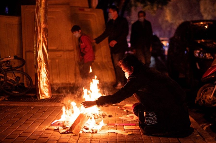 Residents burn paper offerings during the annual Qingming Festival in Wuhan, April 4, 2020. (Noel Celis/AFP)