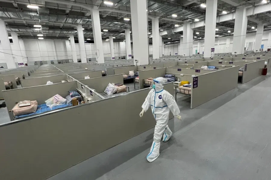 A staff member walks inside a makeshift hospital for Covid-19 patients in Shanghai on 7 April 2022. (AFP)