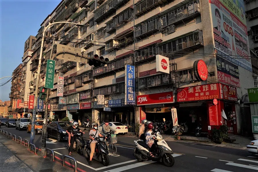 People ride their motorbikes during sunset hours in New Taipei City, Taiwan, 14 July 2022. (Ann Wang/Reuters)
