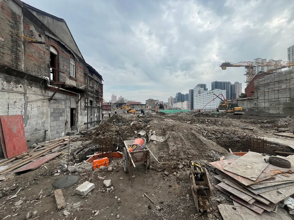 Laying the foundation for new construction within view of yet-to-be-demolished buildings.