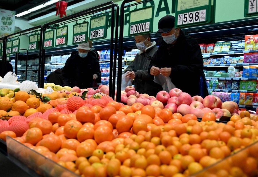 People buy fruits at a market in Beijing on 17 January 2022. (Noel Celis/AFP)