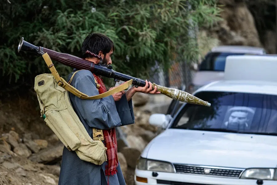 An Afghan armed man supporting the Afghan security forces against the Taliban carries a weapon as he walks along a road in Bazarak, Panjshir province, Afghanistan, on 18 August 2021. (Ahmad Sahel Arman/AFP)