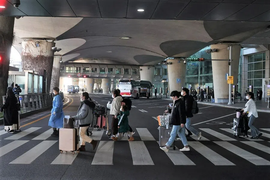 A South Korean soldier wearing personal protective equipment leads a group of Chinese tourists to the Covid-19 testing centre upon their arrival at the Incheon International Airport in Incheon, South Korea, 12 January 2023. (Kim Hong-Ji/Reuters)