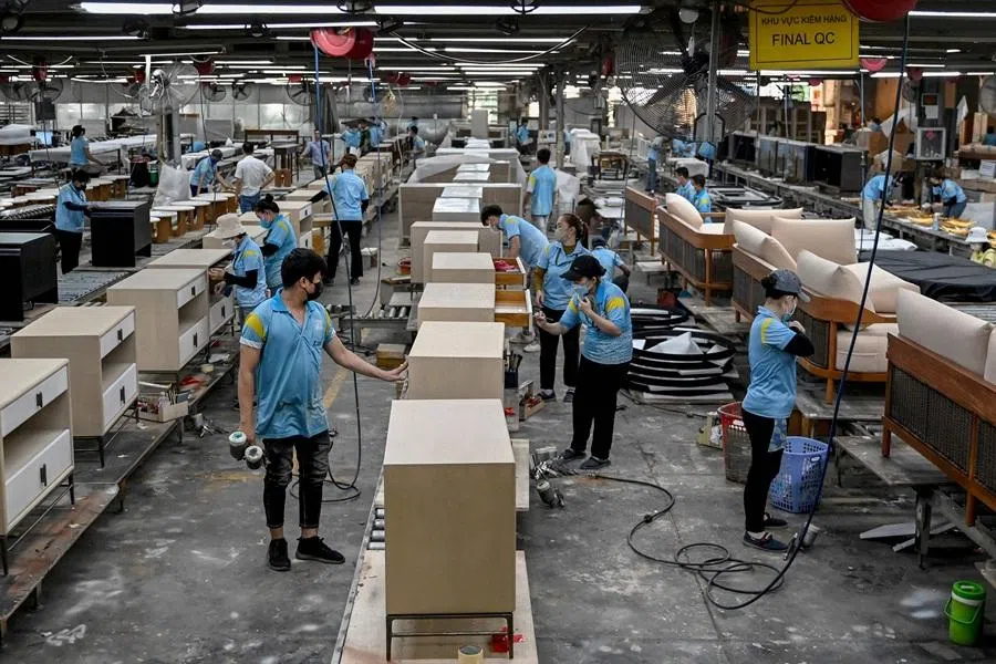 This photo taken on 4 November 2025 shows employees assembling furniture inside a factory in Ho Chi Minh City. (Nhac Nguyen/AFP)