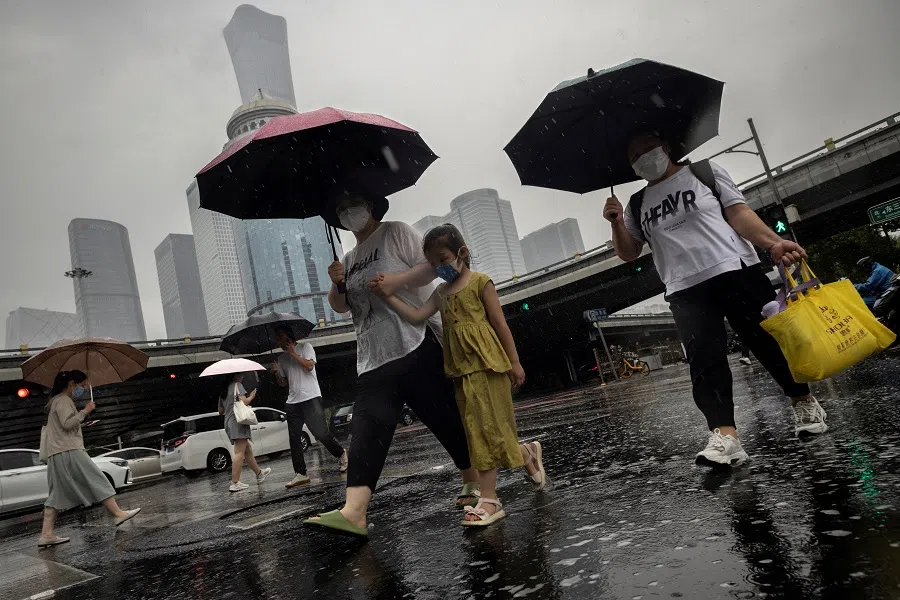 People walk in the central business district, in Beijing, China, on 12 July 2023. (Thomas Peter/File Photo/Reuters)