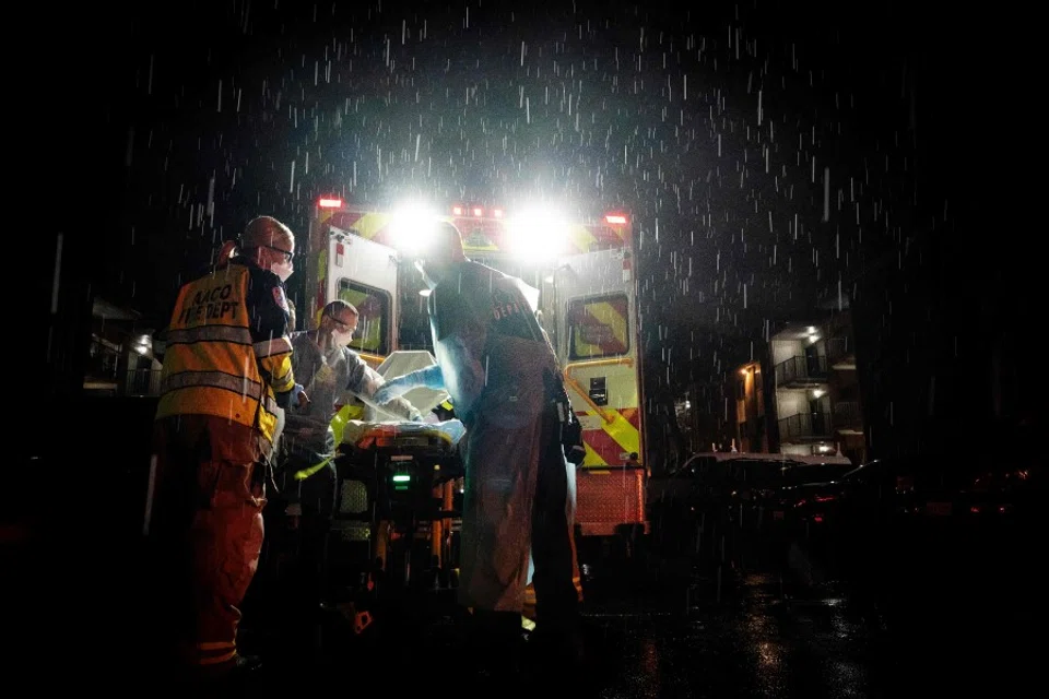Firefighters and paramedics with Anne Arundel County Fire Department wear enhanced PPE while preparing to transport a suspected coronavirus patient, 3 May, 2020. (Alex Edelman/AFP)