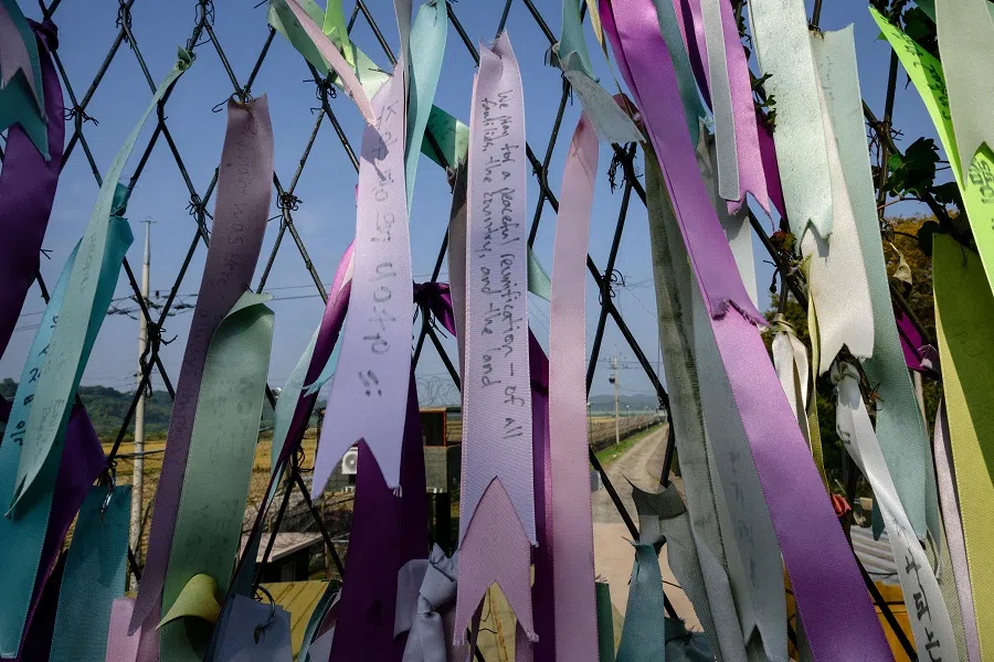 Ribbons with messages wishing for peace and reunification of the Korean peninsula are seen attached to a military fence at the Imjingak peace park near the Demilitarized Zone (DMZ) dividing the two Koreas in Paju on 17 October 2024. (Anthony Wallace/AFP)
