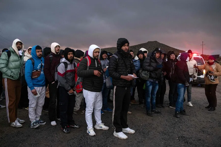 Asylum seekers wait in line to be processed by the Border Patrol at a makeshift camp near the US-Mexico border east of Jacumba, San Diego, California, US, on 2 January 2024. (Guillermo Arias/AFP)