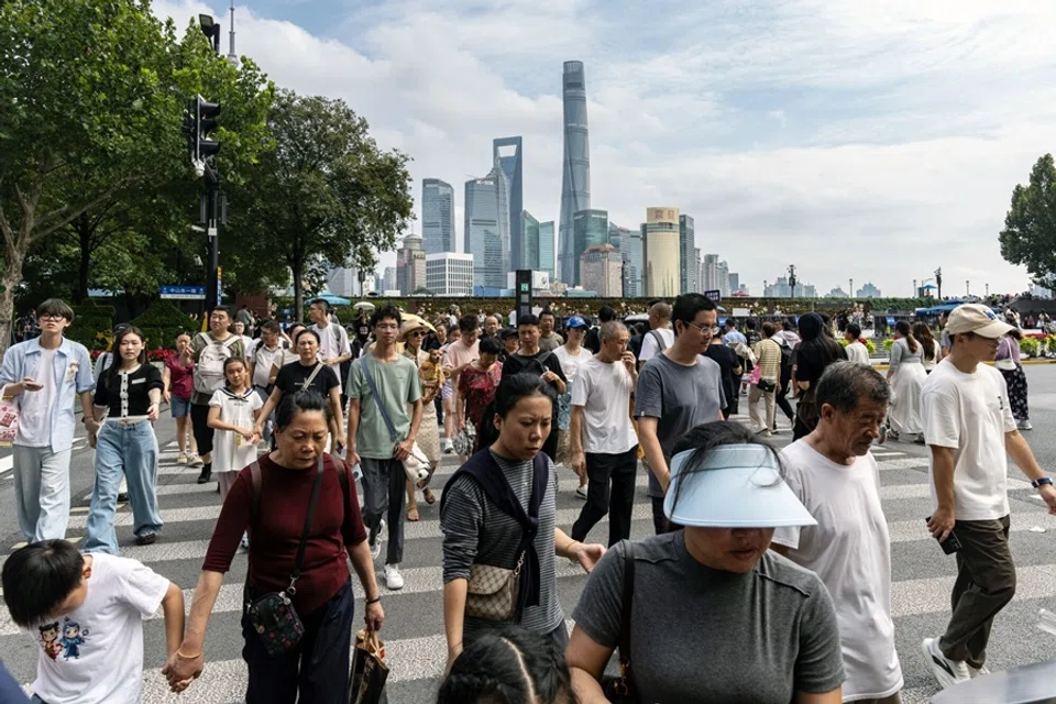 Pedestrians cross a road in the Bund in front of buildings in Pudong's Lujiazui Financial District during the Golden Week holiday in Shanghai, China, on 2 October 2025. (Qilai Shen/Bloomberg)