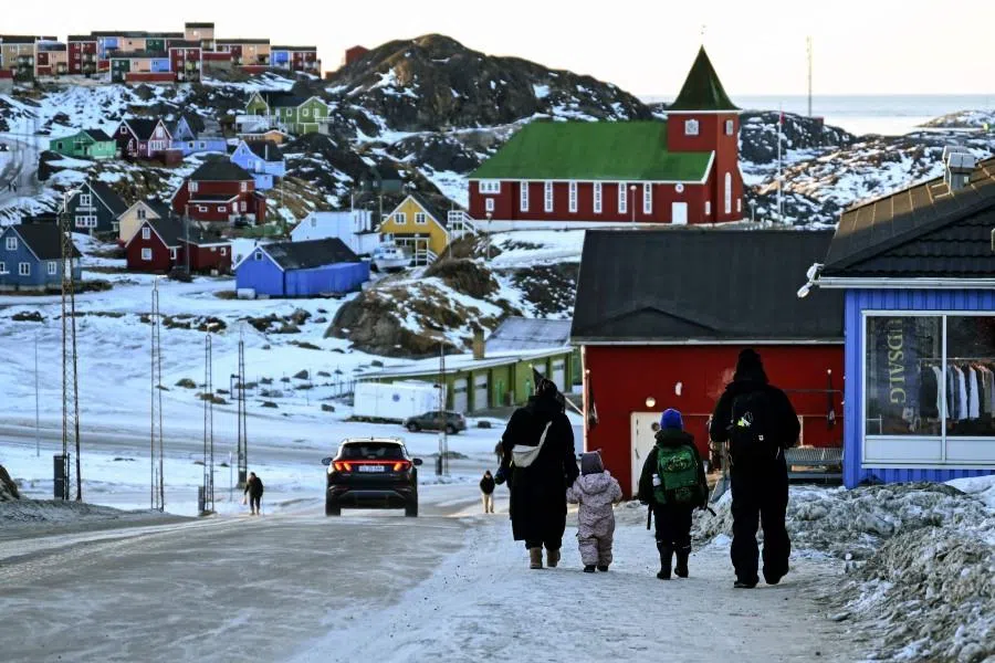 A family walks past a street at the city of Sisimiut, Greenland, on 30 January 2026. (Ina Fassbender/AFP)