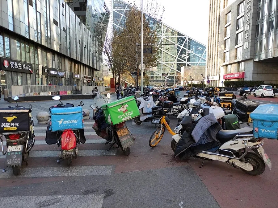 Delivery motorcycles parked by the roadside.