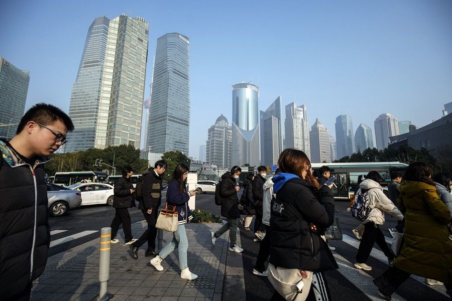 Pedestrians cross a road in Pudong's Lujiazui Financial District in Shanghai, China, on Tuesday, on 9 January 2024. (Qilai Shen/Bloomberg)