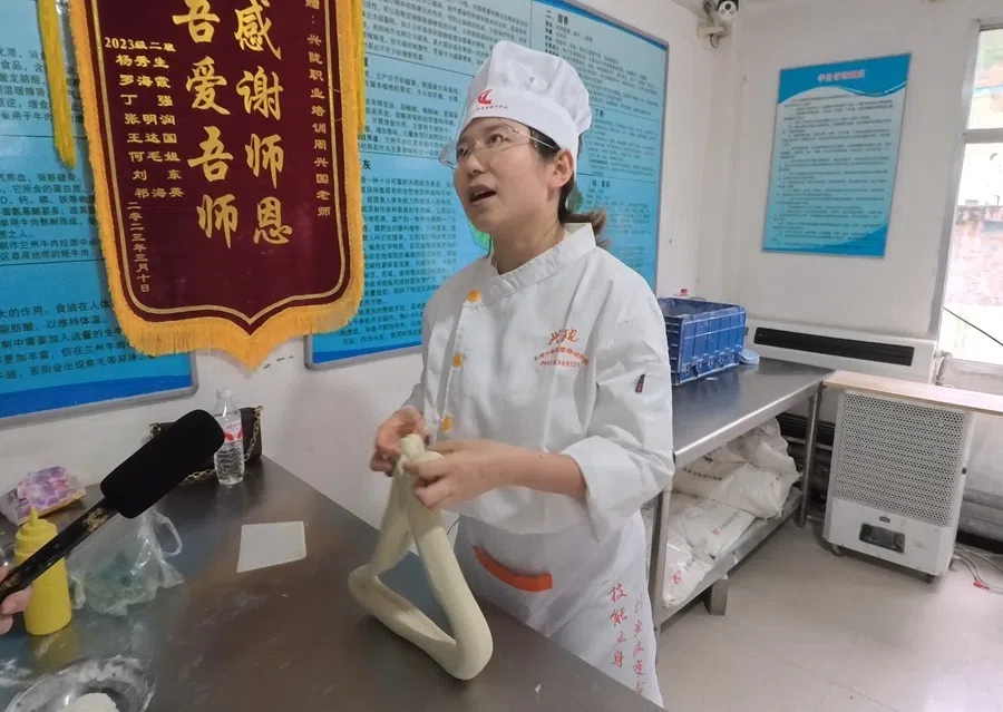 Xiao Sun being interviewed at the Gansu Xinglong Lanzhou Beef Noodle Vocational Training School.
