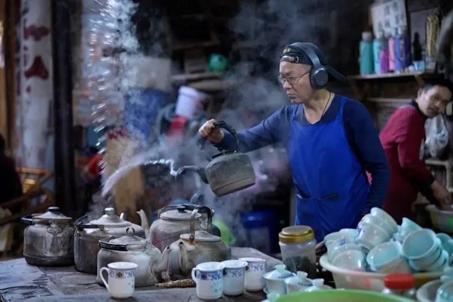 Li Qiang, owner of Pengzhen Old Teahouse, swings a boiling kettle through the air with ease.