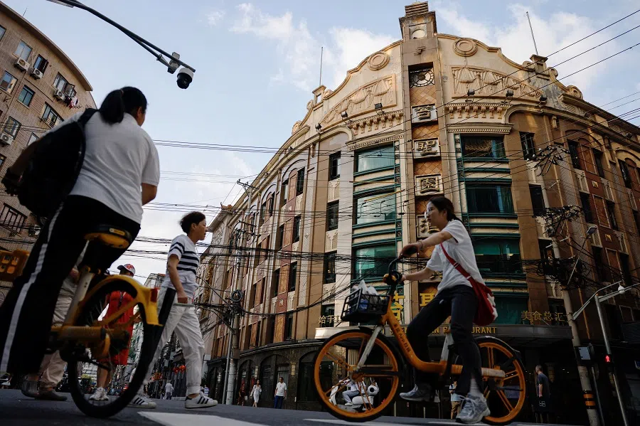 People ride bikes in Shanghai, China, on 28 September 2024. (Tingshu Wang/Reuters)
