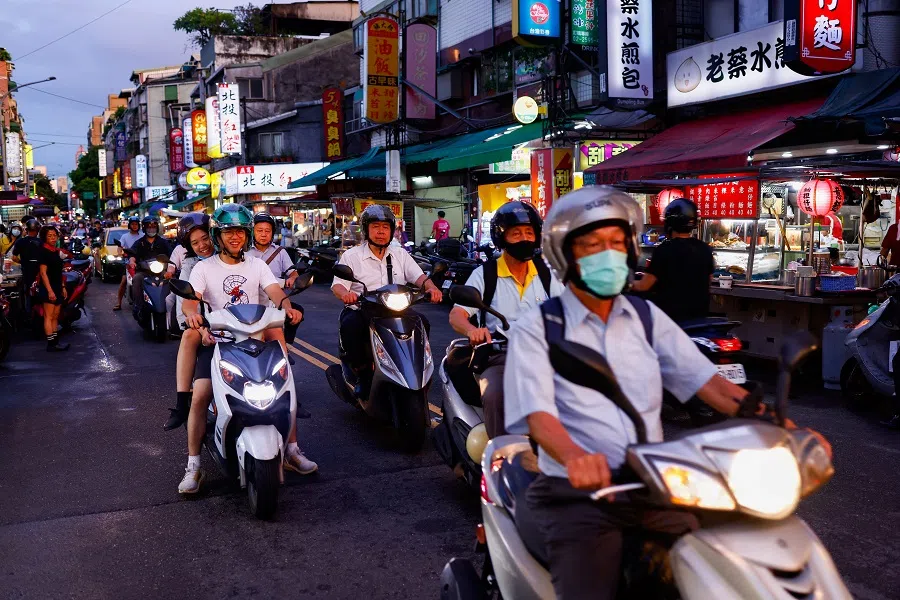 People ride scooters to a night market in Taipei, Taiwan, on 9 July 2024. (Ann Wang/Reuters)