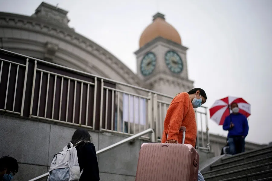 Travellers climb a flight of stairs at Hankou Railway Station after the lockdown was lifted in Wuhan, China's epicentre Covid-19 outbreak, on 10 April 2020. (Aly Song/Reuters)