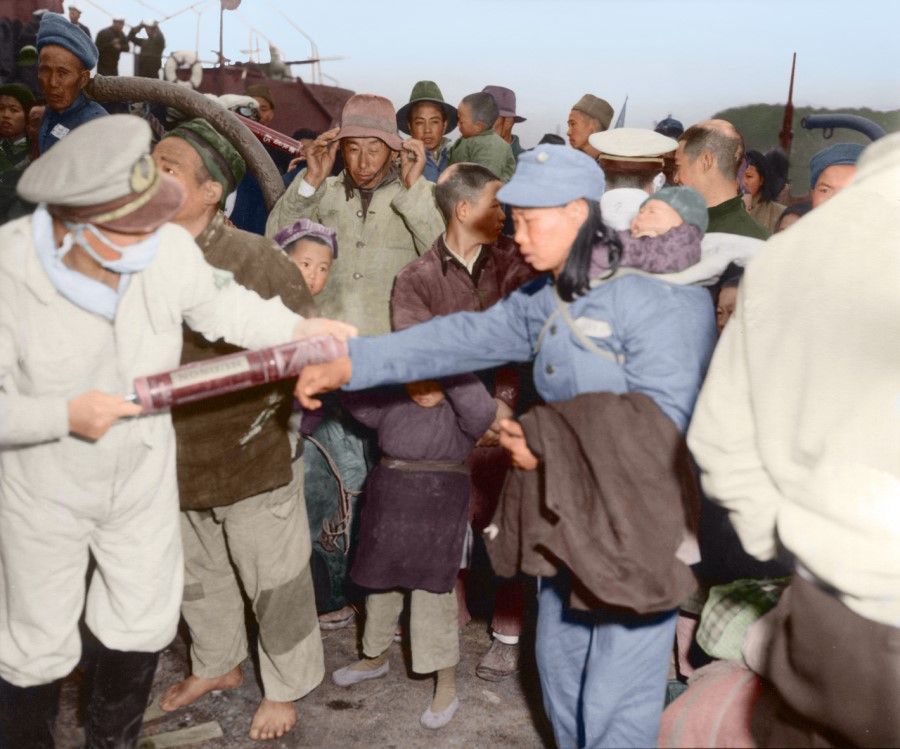 In February 1955, the KMT government decided to move over 20,000 residents on the remote - and hard-to-defend - Dachen islands off Zhejiang to Taiwan. The photo shows health officials using spray dispensers to decontaminate Dachen residents arriving at Keelung port.