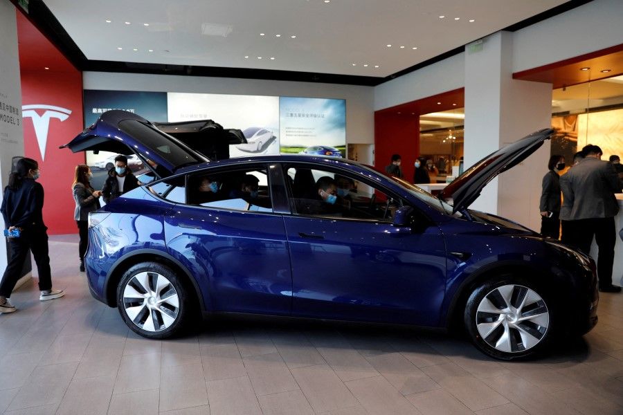 Visitors check a Tesla Model Y sport utility vehicle (SUV) at the company's showroom in Beijing, China, 5 January 2021. (Tingshu Wang/Reuters)