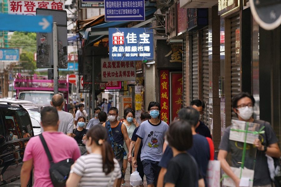 People wearing face masks walk on a street in Hong Kong on 11 August 2020. (Lam Yik/Reuters)