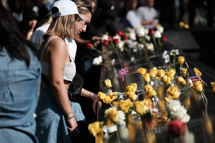 People pause at the September 11th Memorial on 10 September 2021 in New York City. (Spencer Platt/Getty Images/AFP)