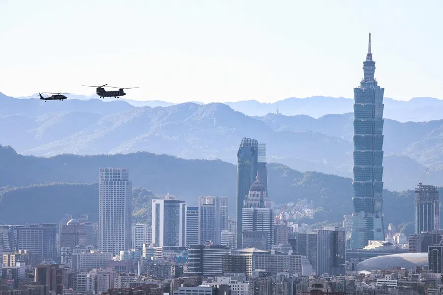 A Sikorsky UH-60M Black Hawk helicopter (left) and a Boeing CH-47SD Chinook tandem-rotor helicopter perform a flyby past the Taipei 101 building in Taipei on 2 October 2025. (I-Hwa Cheng/AFP)