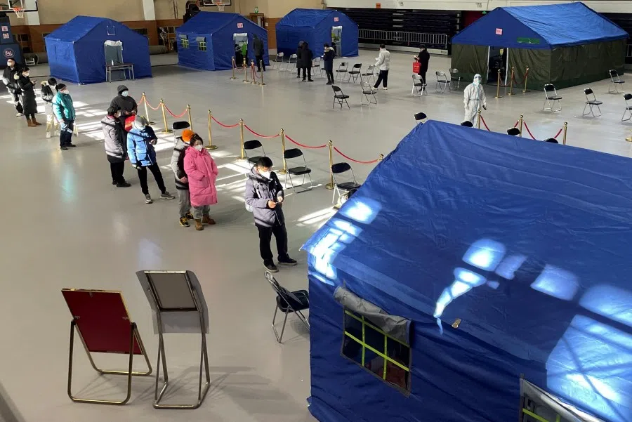 People line up at a makeshift fever clinic set up inside a stadium, amid the coronavirus disease (Covid-19) outbreak in Beijing, China, 19 December 2022. (Alessandro Diviggiano/Reuters)