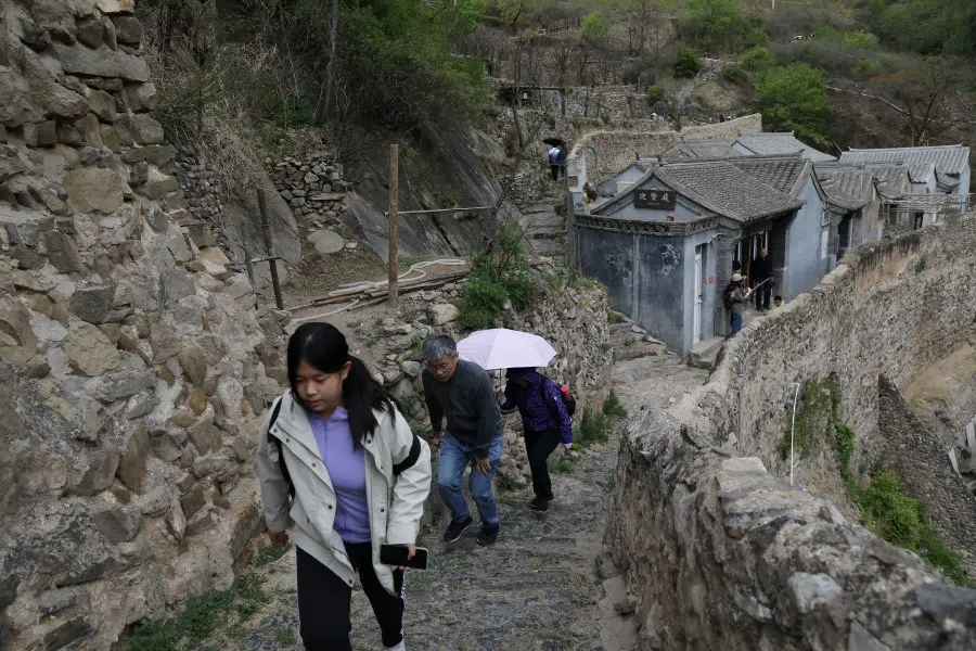 People walking in a historic village which is now a tourist attraction during the five-day Labour Day holiday in the suburbs of Beijing, China, 4 May 2021. (Tingshu Wang/Reuters)