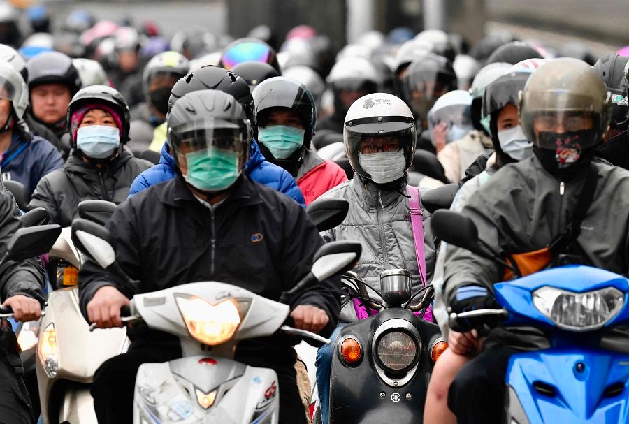 Motorcyclists wearing face masks amid the Covid-19 pandemic ride during the peak hours while heading to work in Taipei on 18 March 2020. (Sam Yeh/AFP)