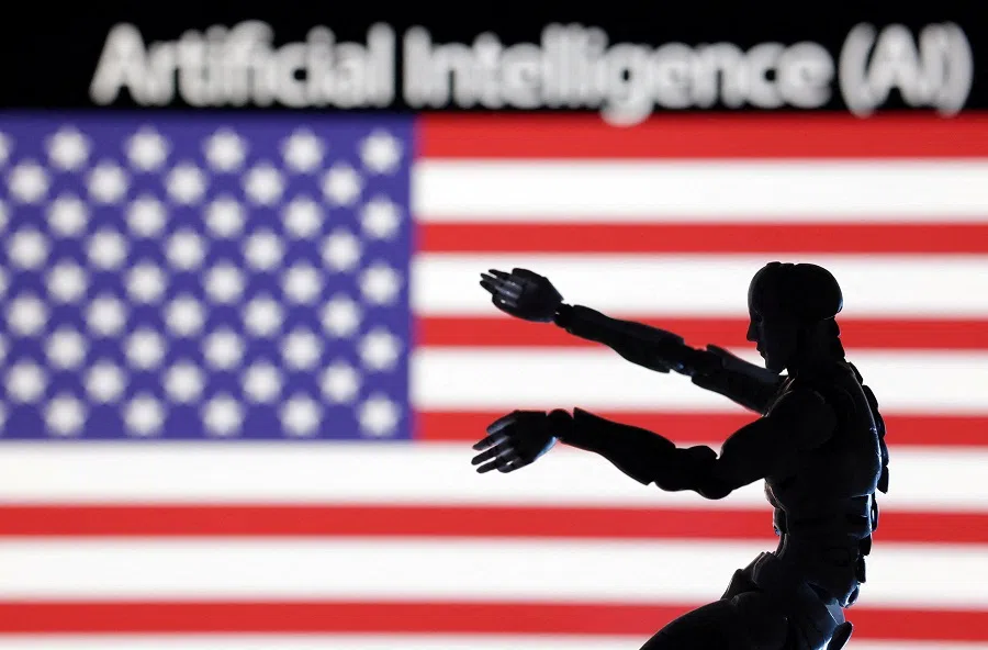The rapid emergence of generative AI has turned the tables on the China-US AI race. This illustration taken 21 December 2023 shows the words "artificial intelligence", a miniature robot and the US flag. (Dado Ruvic/Illustration/Reuters)
