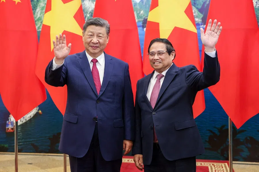 Vietnam’s Prime Minister Pham Minh Chinh (right) and China’s President Xi Jinping pose for photos before their meeting at the Office of the Party Central Committee in Hanoi on 14 April 2025. (Minh Hoang/AFP)