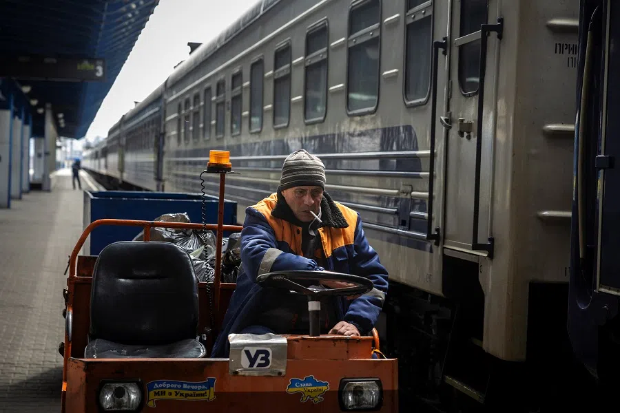 A worker of the Ukrzaliznytsia Ukrainian Railway company drives a luggage cart past a stationary train at the main train station in Kyiv, on 24 March 2025. (Thomas Peter/Reuters)