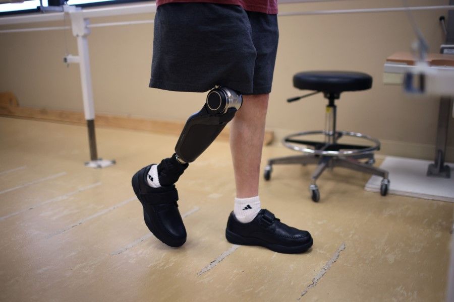 A man wears a prosthetic leg featuring a prosthetic knee that uses artificial intelligence (AI) to learn human movement patterns and assist with those movements, 10 November 2021. (Scott Olson/AFP)