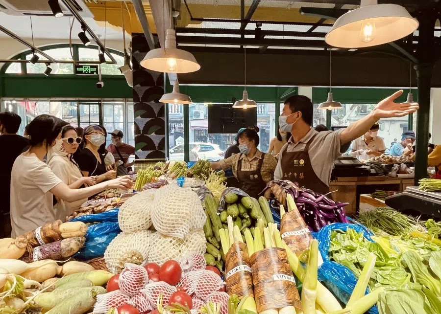 A vegetable stall in Wuzhong Market with produce wrapped in Prada packaging. (Photo: Chen Jing)