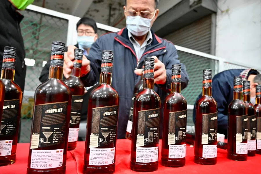 Workers of Taiwan Tobacco and Liquor Corporation display bottles of rum imported from Lithuania in Taoyuan on 22 January 2022, after the state-run liquor company snapped up some 20,000 bottles of the spirit that were blocked from China after a diplomatic row broke out between Beijing and Vilnius. (Sam Yeh/AFP)
