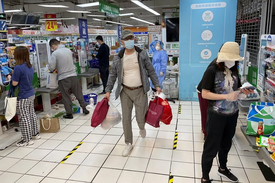 Customers wearing face masks use self-checkout counters at a reopened Carrefour supermarket amid a Covid-19 outbreak in Shanghai, China, on 19 May 2022. (Brenda Goh/Reuters)