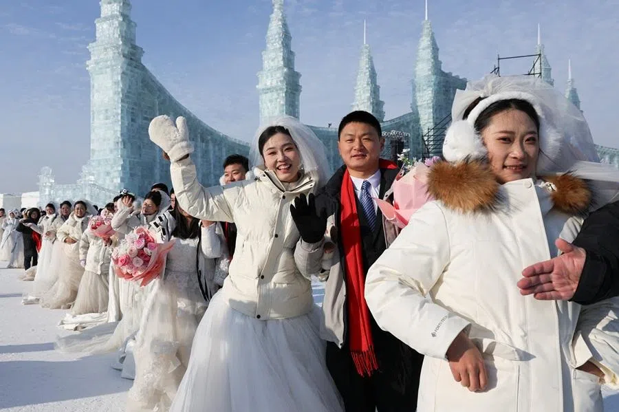 Couples line up to pose for photos after the group wedding ceremony at the annual Harbin International Ice and Snow Sculpture Festival in Harbin, Heilongjiang province, China, on 6 January 2026. (Go Nakamura/Reuters)