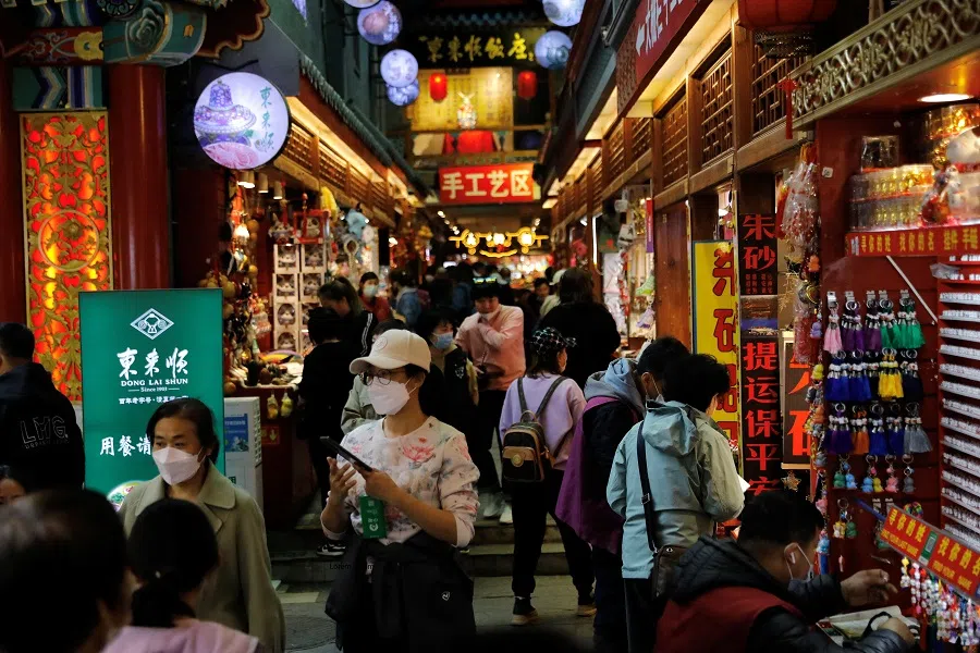 People visit a market at the tourism site of Qianmen Street, in Beijing, China, 14 March 2023. (Tingshu Wang/Reuters)