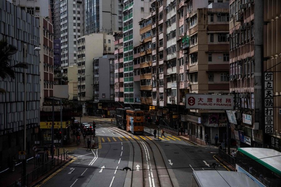 Trams (centre) travel along a street in Hong Kong on 25 August 2022, amid a typhoon warning as Severe Tropical Storm Ma-on passed closest to the city in the early morning. (Isaac Lawrence/AFP)