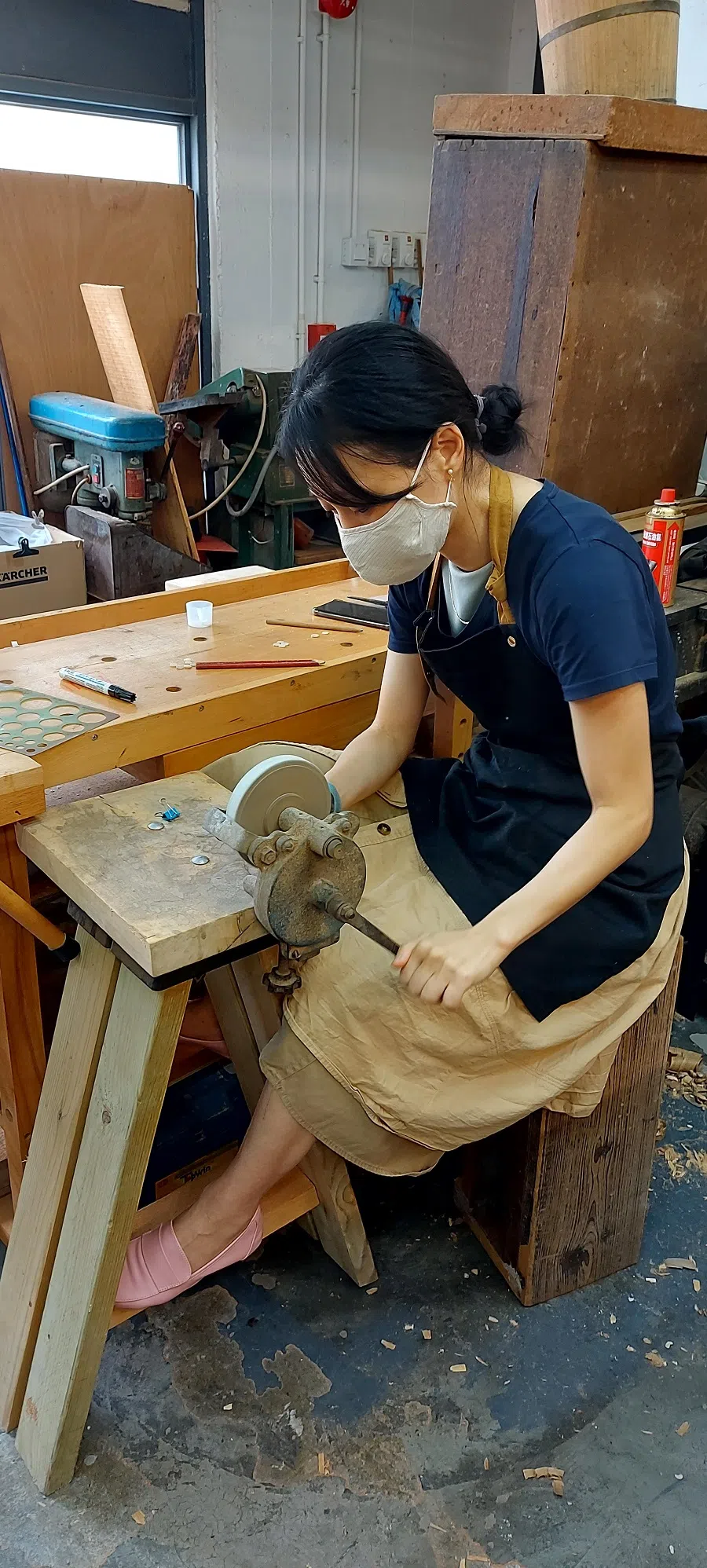 A student enrolled through the CCS Qin Making Society grinding shells for setting as nodes for her guqin top board.