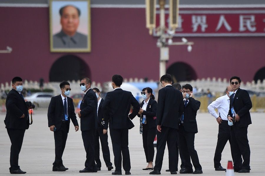 Security personnel are seen outside the Great Hall of the People for the second plenary session of the National People's Congress as a portrait of late communist leader Mao Zedong (back, left) is seen in the distance at Tiananmen Square in Beijing on 25 May 2020. (Noel Celis/AFP)