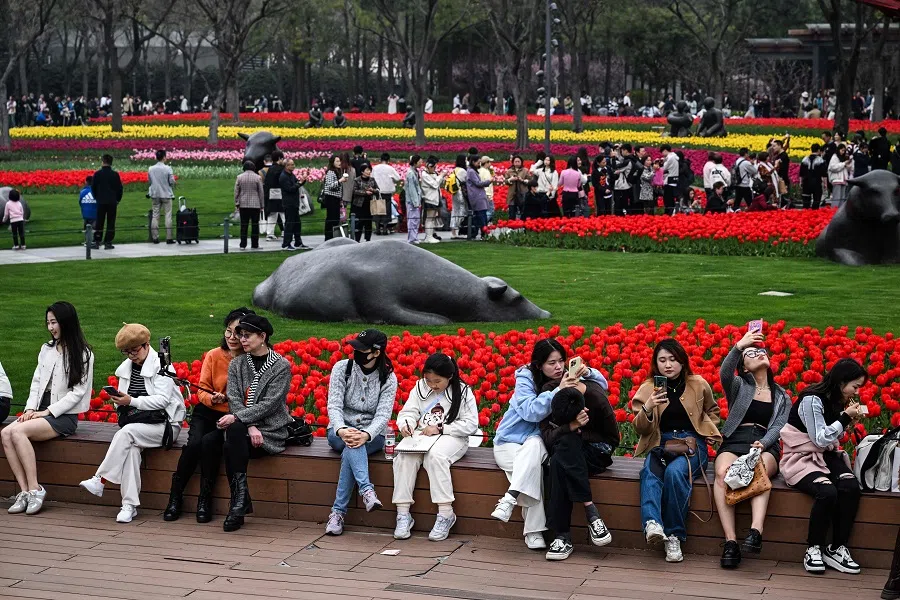 People visit the Jing'an sculpture park in the Jing'an district in Shanghai on 24 March 2024. (Hector Retamal/AFP)