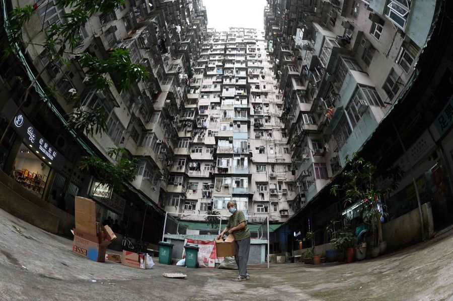 This file photo taken on 22 March 2022 shows a woman collecting cardboard at a housing estate in Hong Kong. (Peter Parks/AFP)