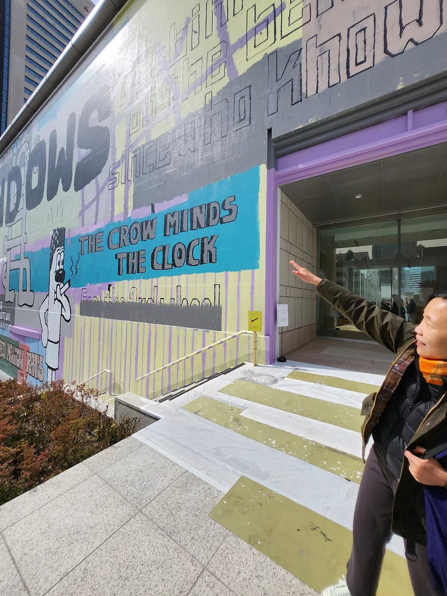 Artistic director Carol Yinghua Lu points to the huge graffiti by Side Core which covers the entire museum rear external wall.