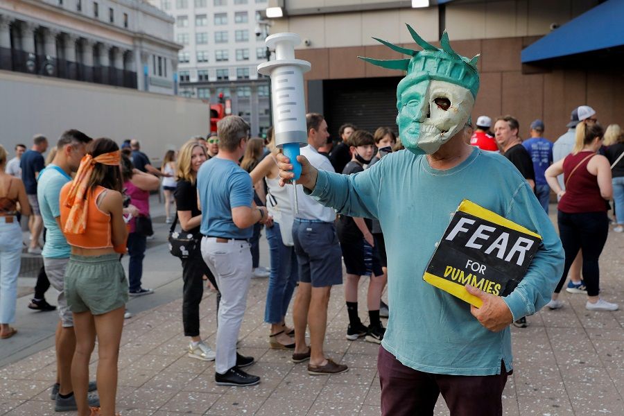 An anti-vaccine protester dressed as the Statue of Liberty holding an oversized syringe attends a gathering outside Madison Square Garden ahead of a Foo Fighters' show, which required proof of vaccination to enter, in New York City, US, 20 June 2021. (Andrew Kelly/Reuters)