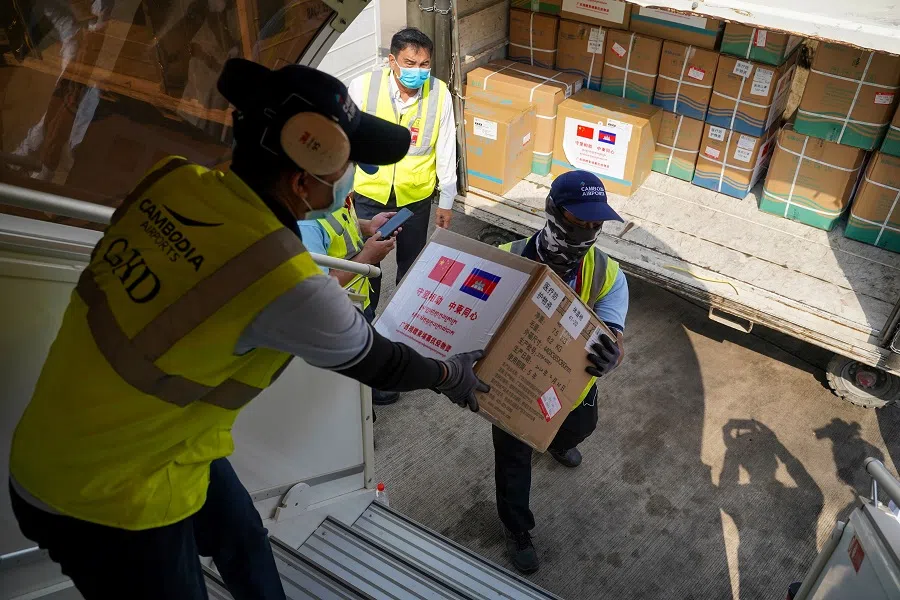 Medical supplies are carried from a plane as a flight arrives from China to Cambodia with supplies and medical staff to contain the spread of the Covid-19 pandemic, at Phnom Penh International Airport in Cambodia, on 23 March 2020. (Cindy Liu/Reuters)