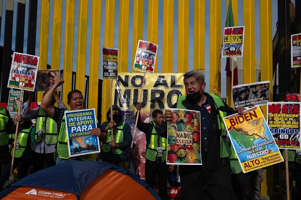 Members of Border Angels and migrants demonstrate at the US-Mexico border as part of International Migrants Day in Playas de Tijuana, Baja California State, Mexico, on 18 December 2023. (Guillermo Arias/AFP)